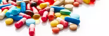 Different colored pills on white background