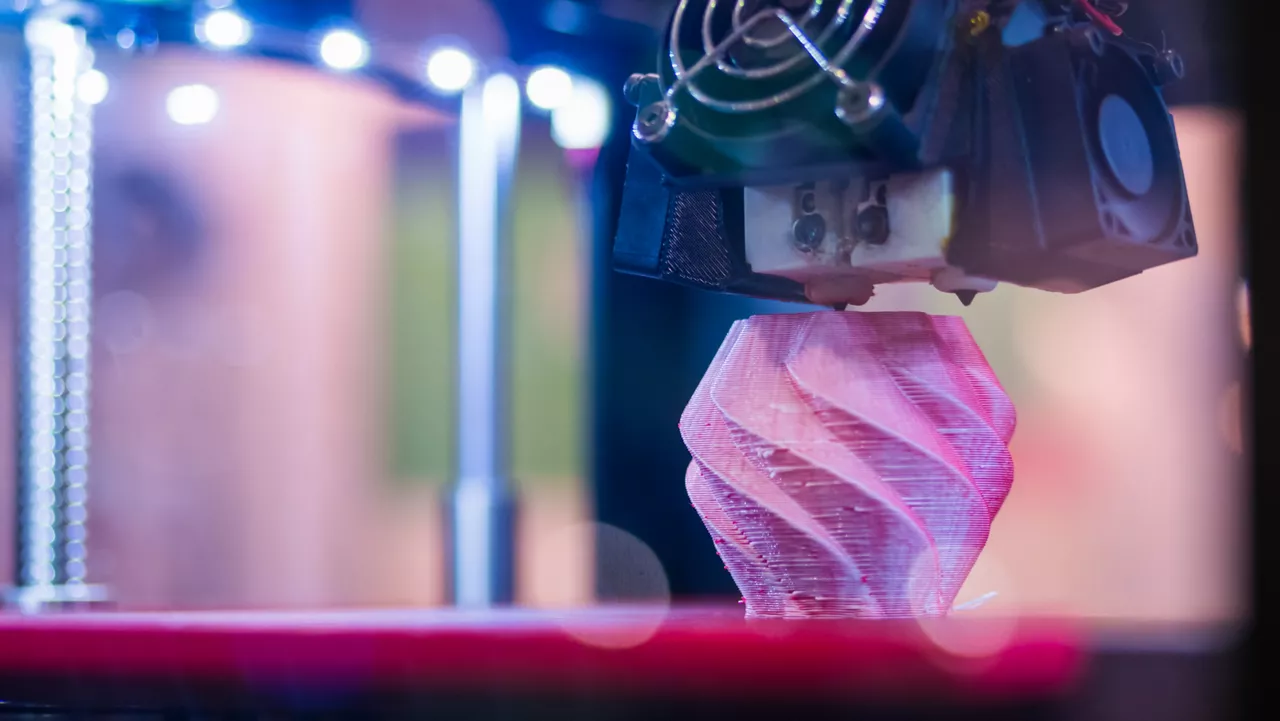 Print head of 3D printer machine printing plastic model at modern scifi technology exhibition. 3D printing, additive technologies, 4.0 industrial revolution and futuristic conceptModern 3D printer machine printing plastic model